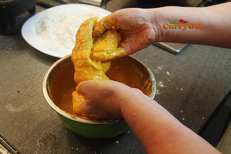 Dipping fish into the batter.