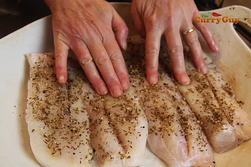 Patting ground spices into fish