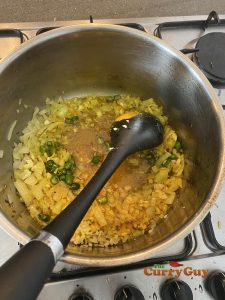 Adding turmeric, chopped garlic, ginger and chillies to pan