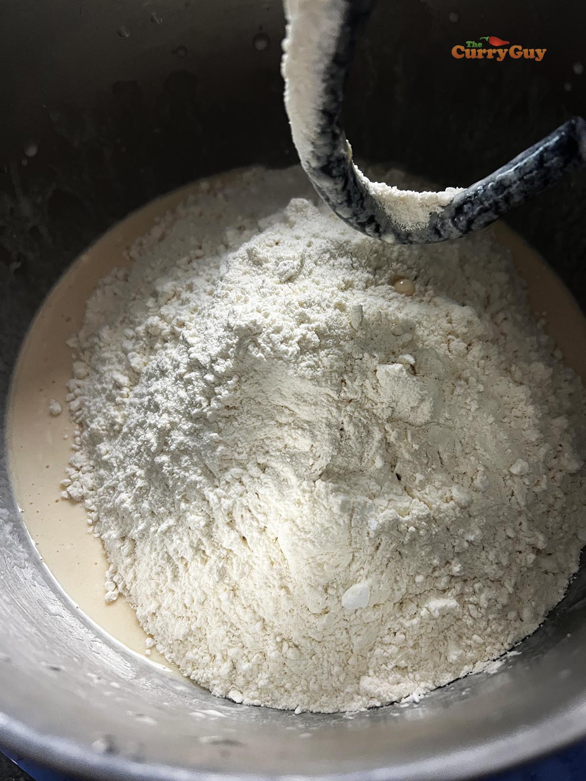 Combining the eggs, yoghurt, milk and yeast with half of the flour.