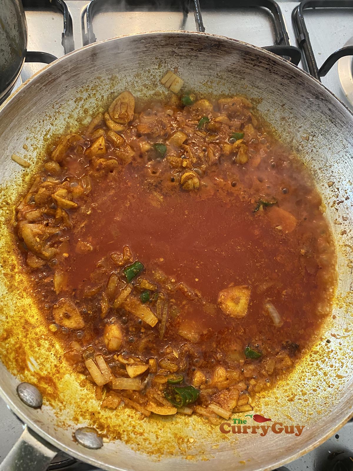 Stirring tomato puree into the pan