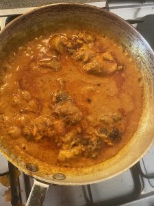 Adding tandoori chicken to the pan
