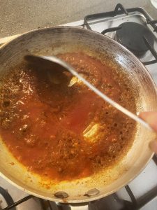 Adding tomato puree to the pan