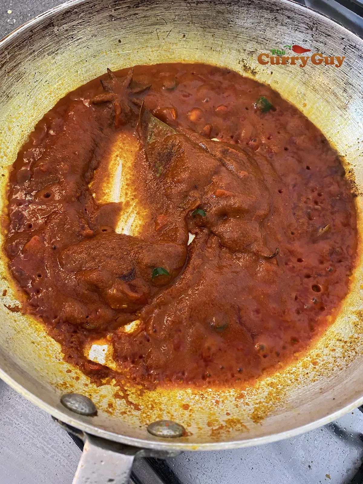 adding tomato puree to the pan