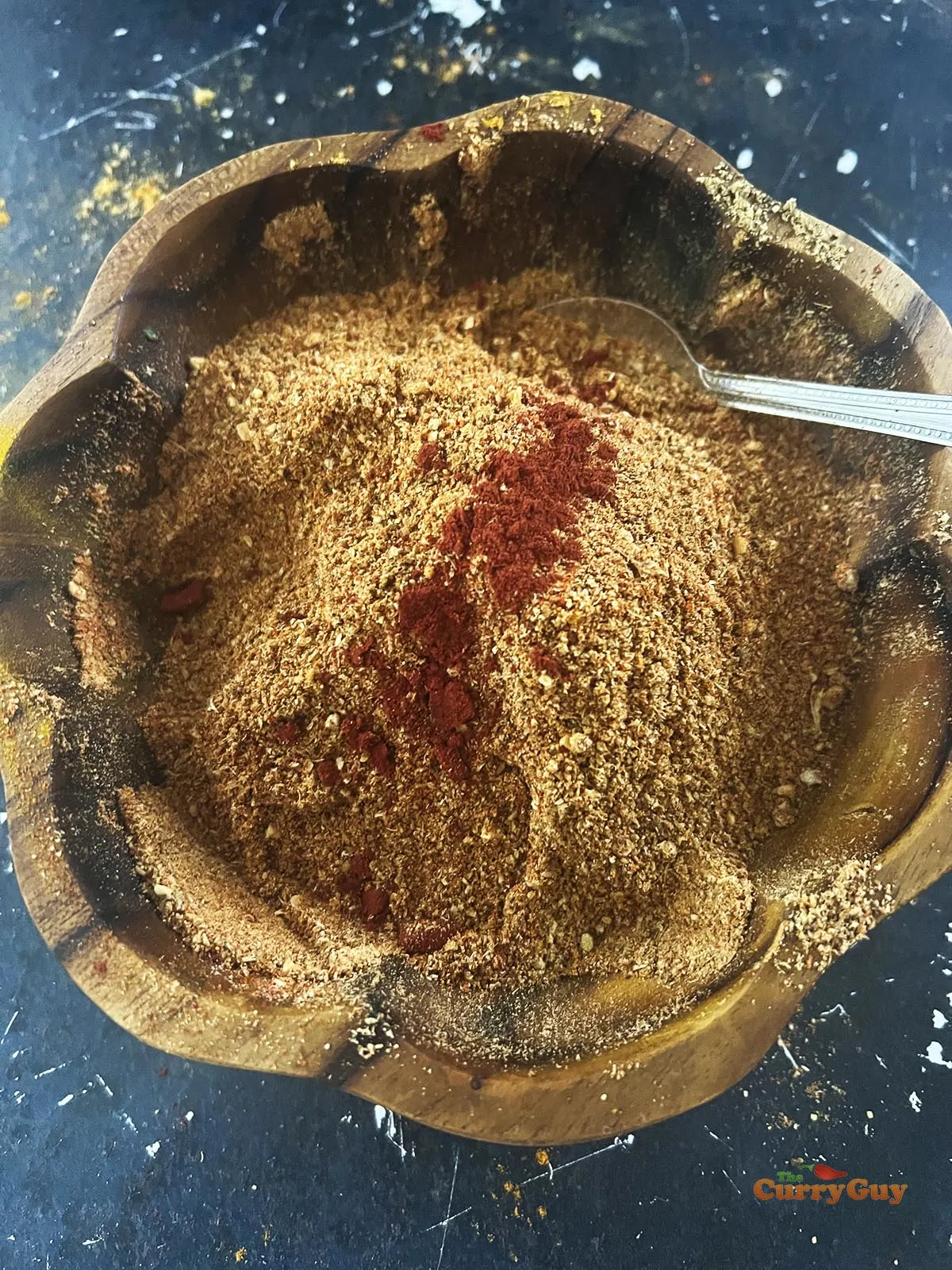 Adding red food colouring to the tandoori masala.