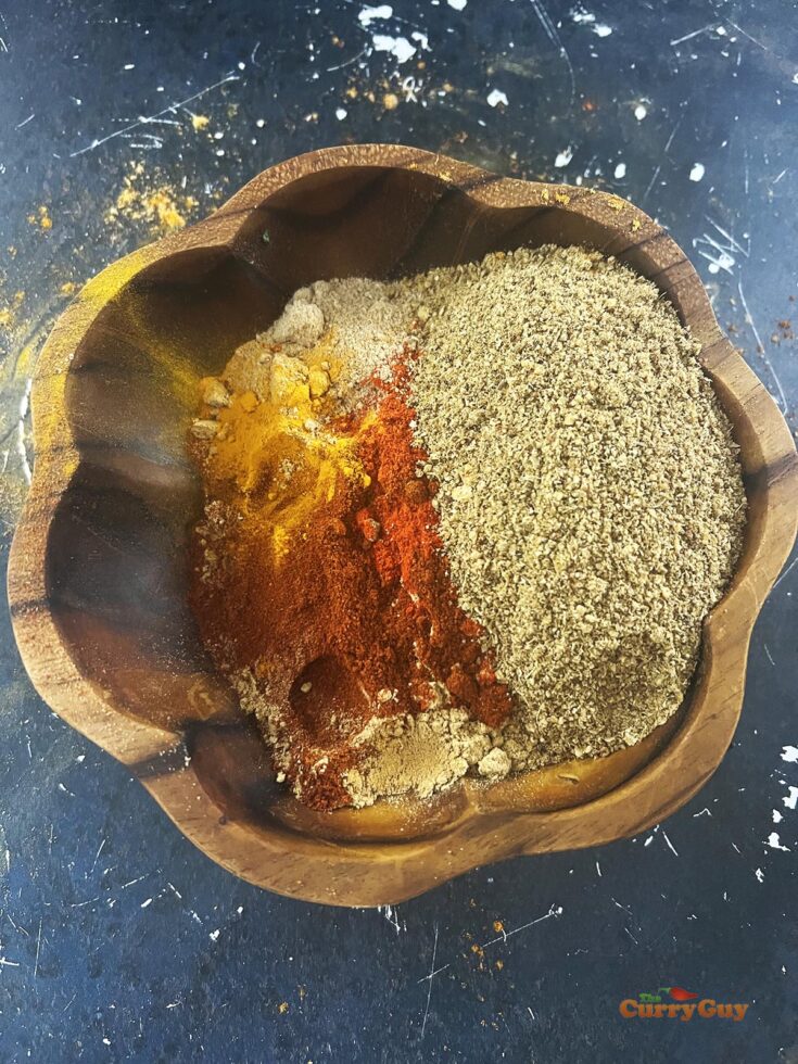 Adding the ground spices to the tandoori masala.