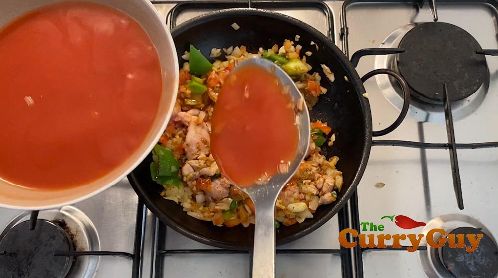 Adding tomato puree to the pan