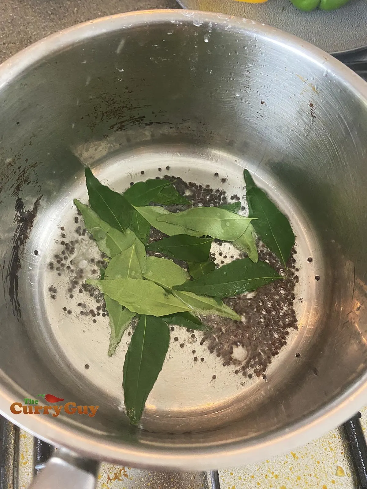 Adding curry leaves to pan