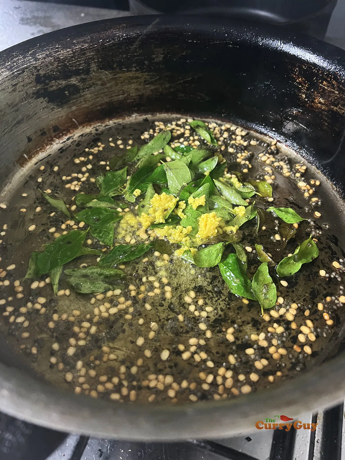 Adding lemon zest and curry leaves to the pan.