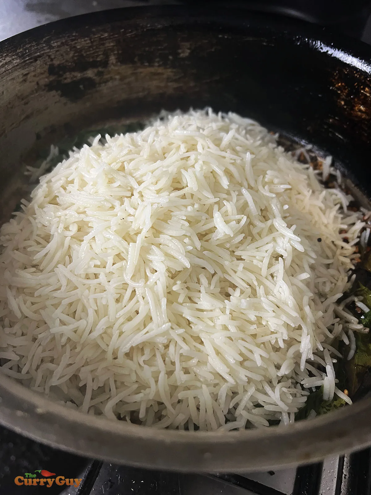 Adding cooked rice to the pan.