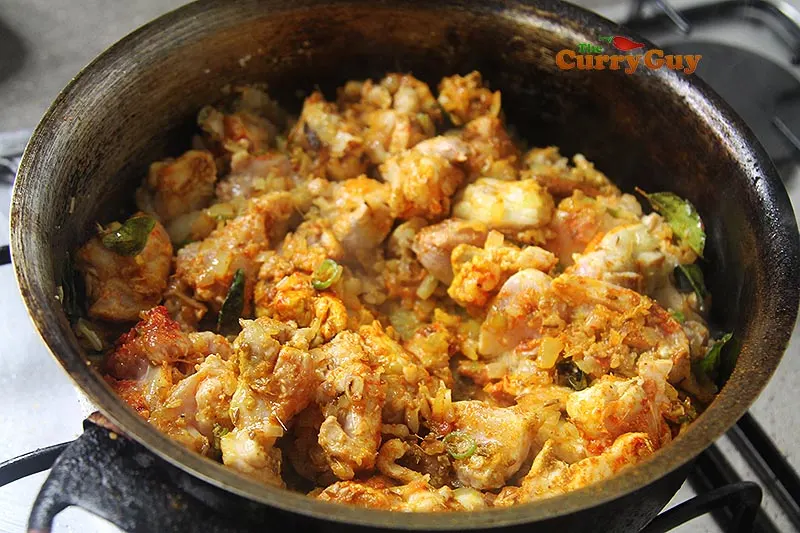 stirring chicken into curry.