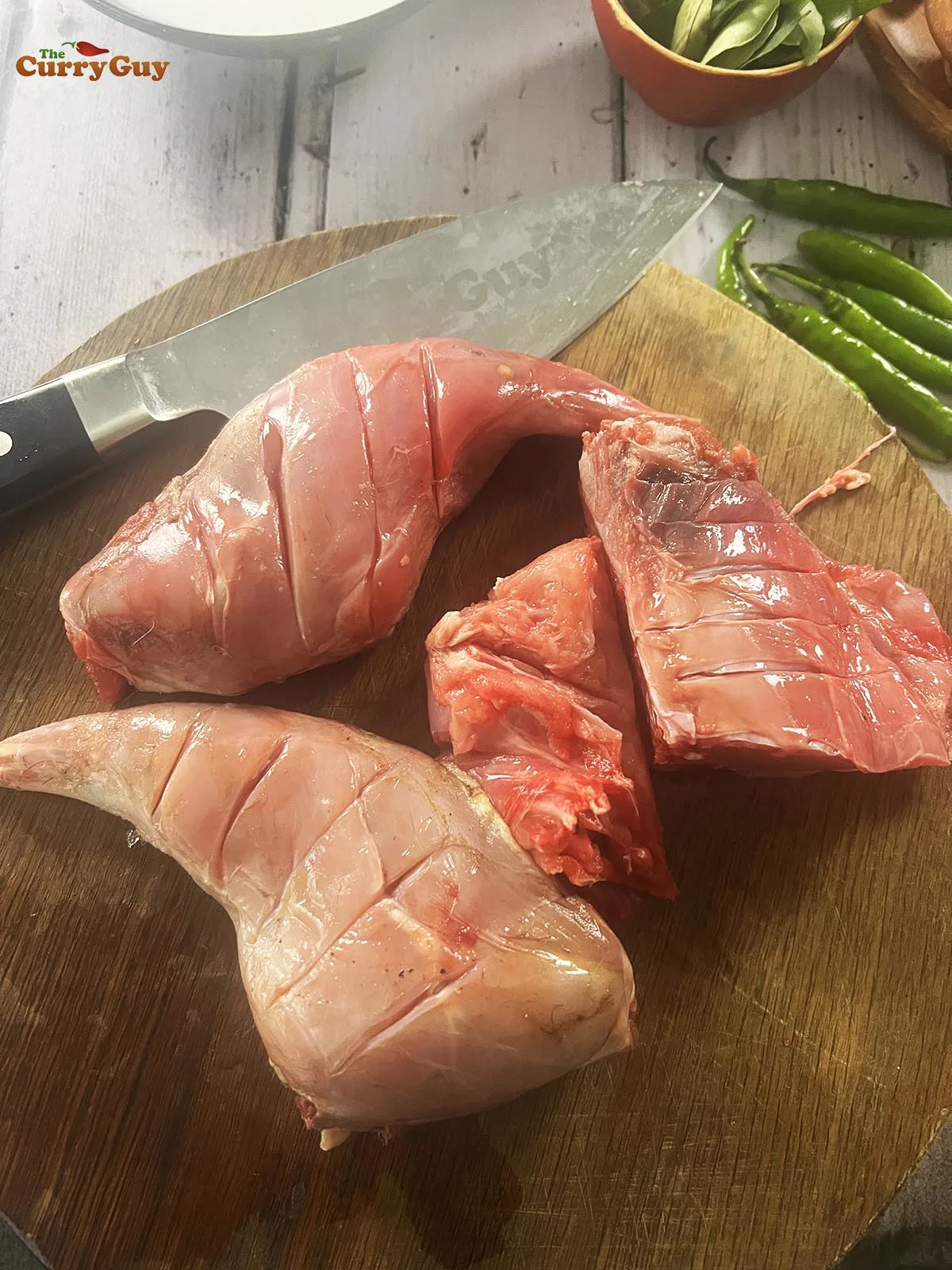 Scoring the rabbit pieces for better penetration of the marinade.