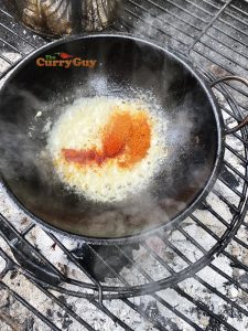 Adding ground spices to balti pan