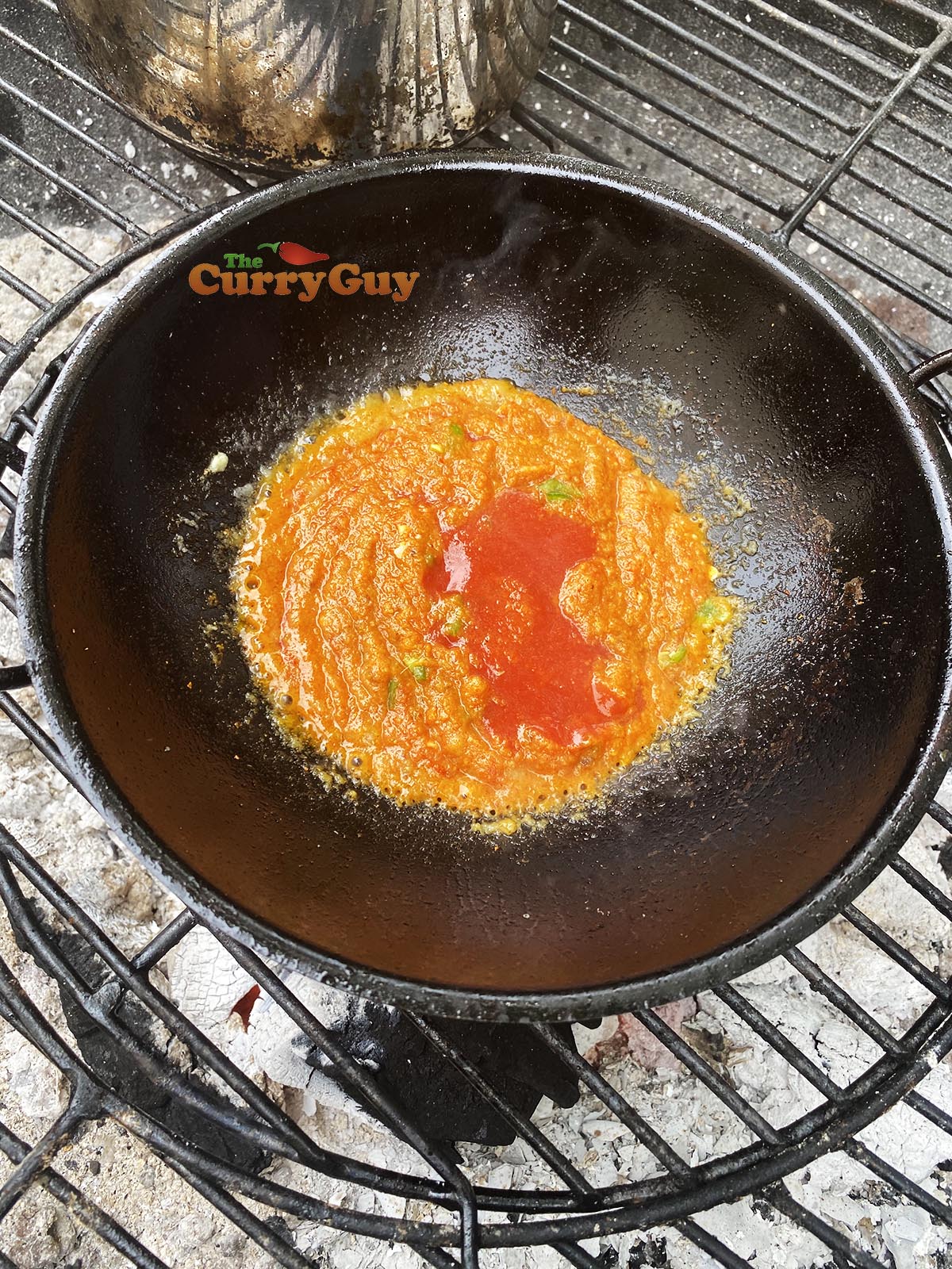 Adding tomato puree to pan