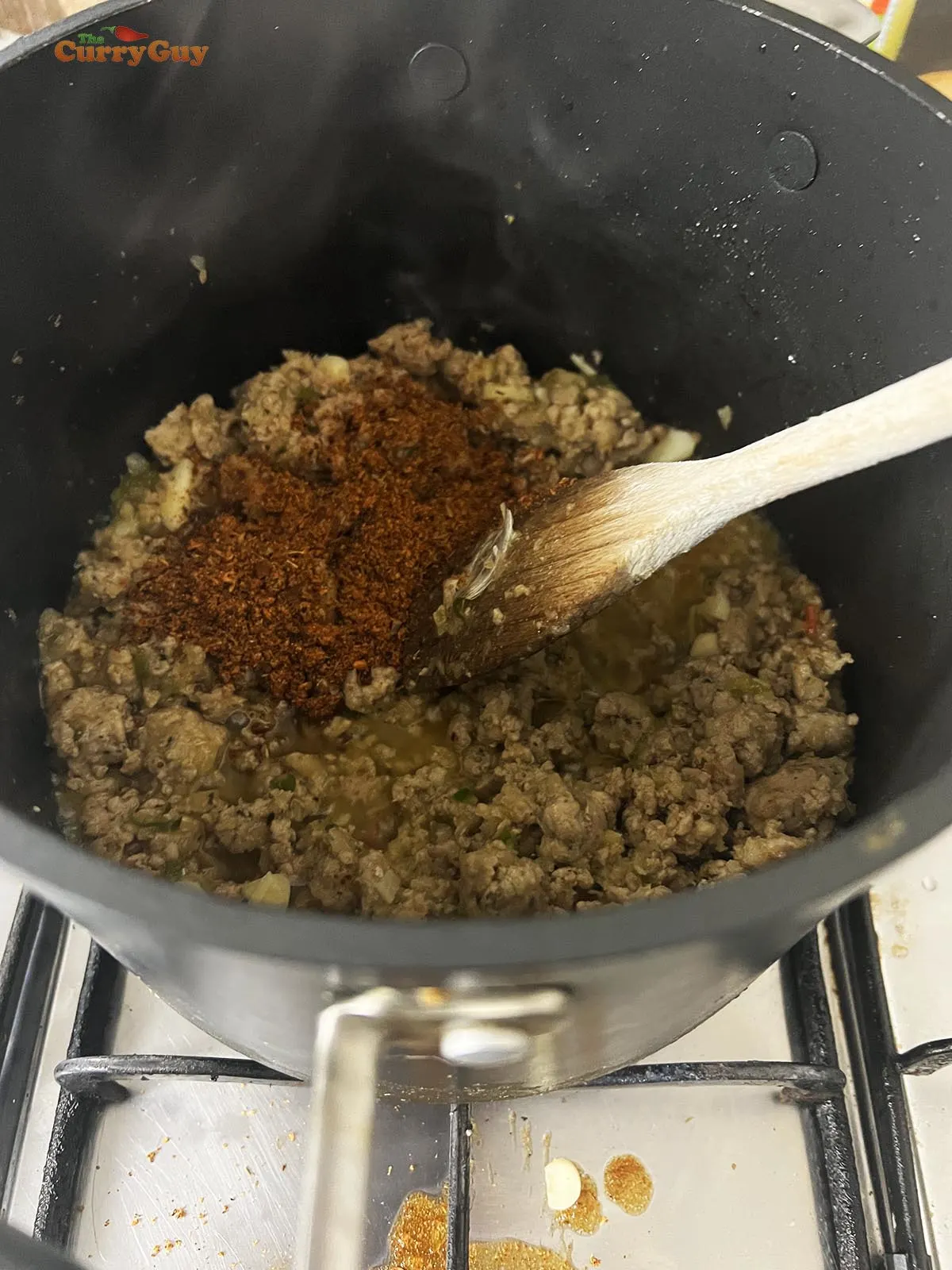 Adding garlic and Cajun spice powder to the pan.
