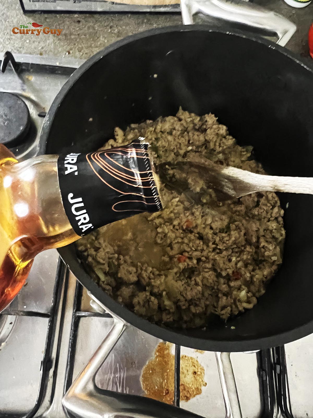 Adding whiskey to the pan.