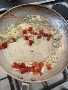 Frying onions and peppers in a pan