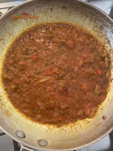 Adding tomato puree to pan