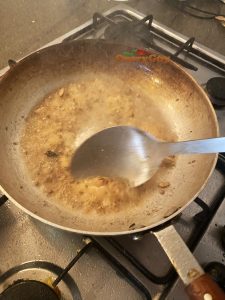 Stirring garlic and ginger paste into the pan