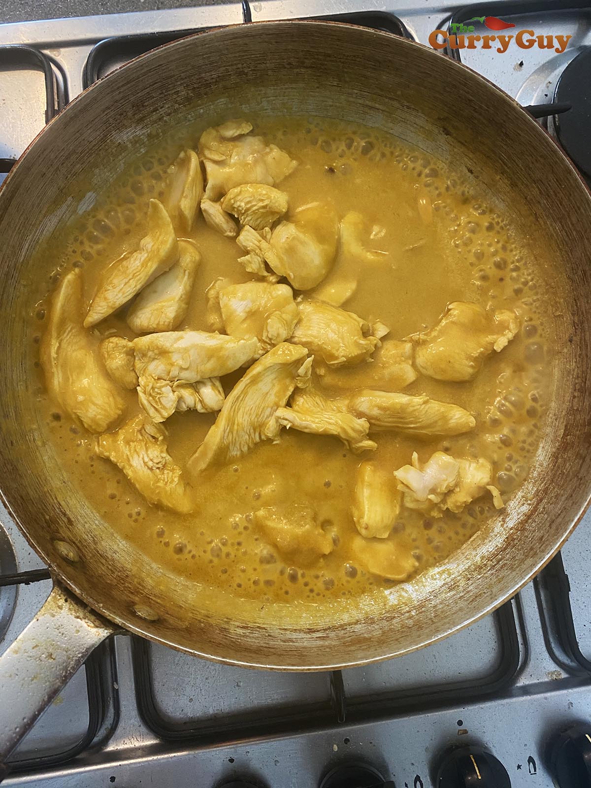 adding chicken to korma
