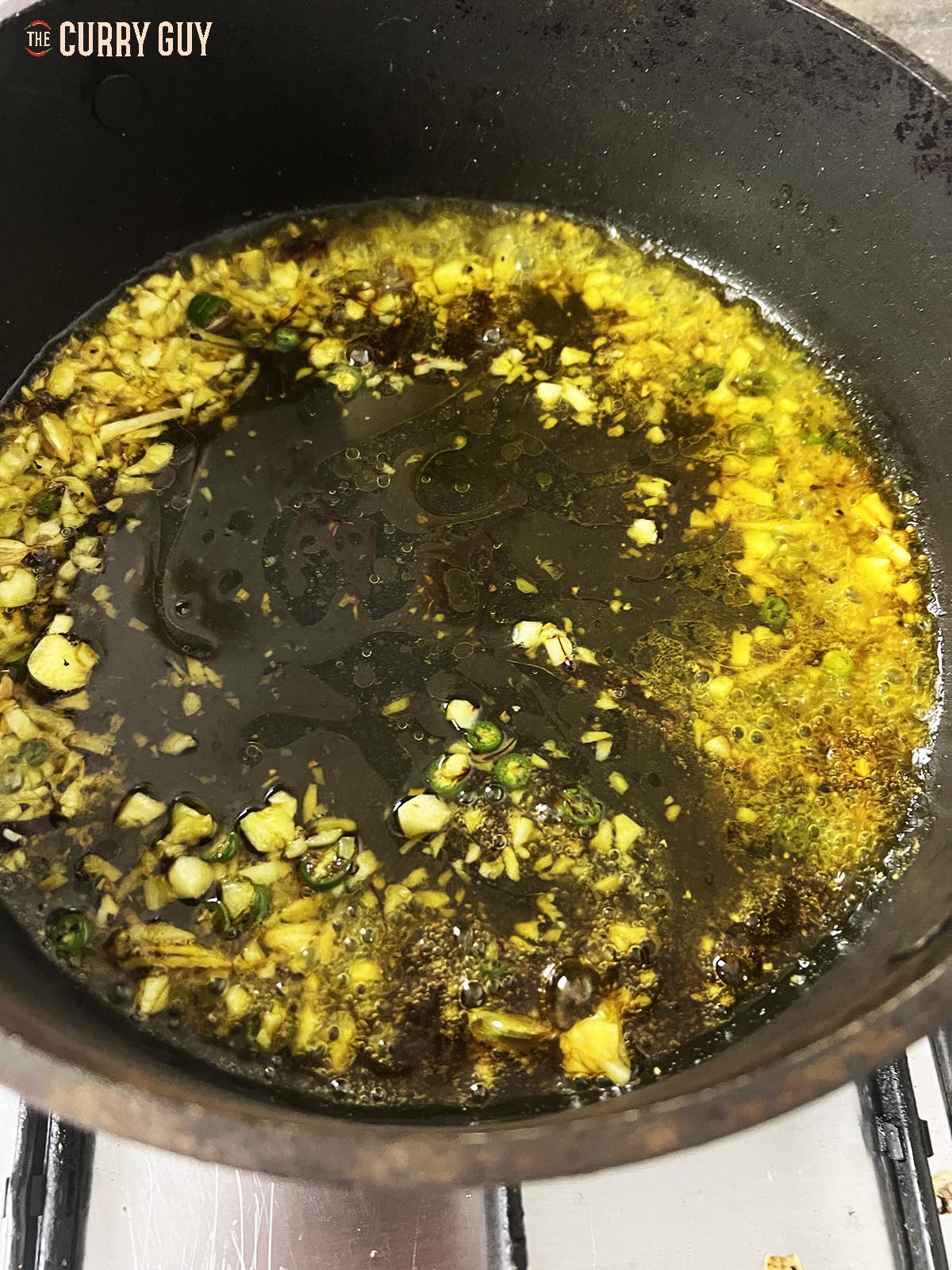 Adding saffron and vinegar to the pan.