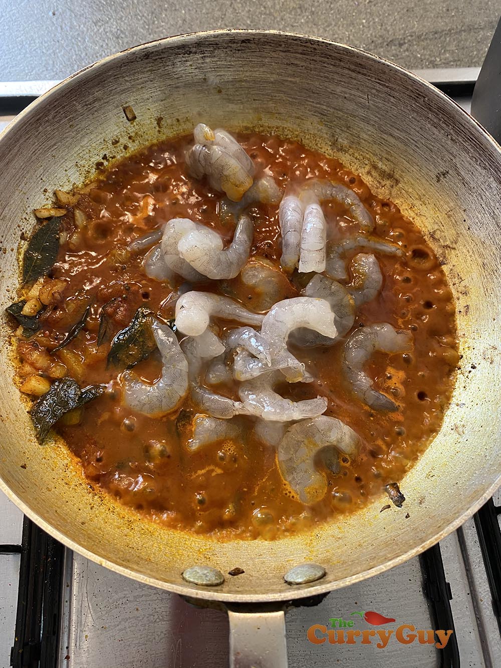 Adding raw prawns to the curry
