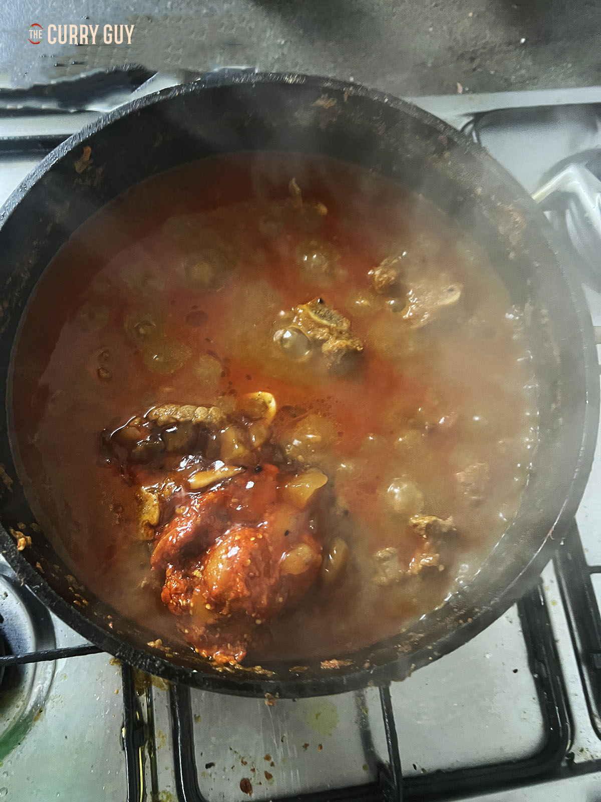 Simmering the meat and adding lime pickle and mango chutney to the pan.