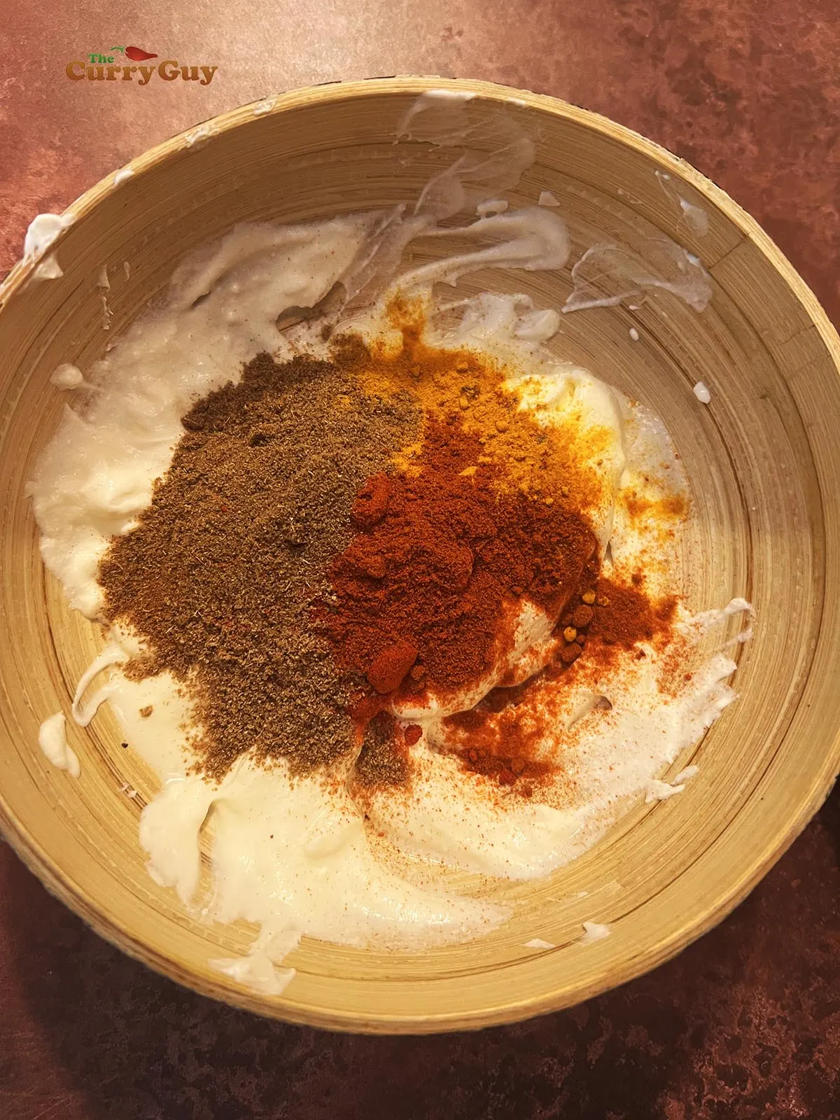 Adding ground spices to yogurt and cream cheese.