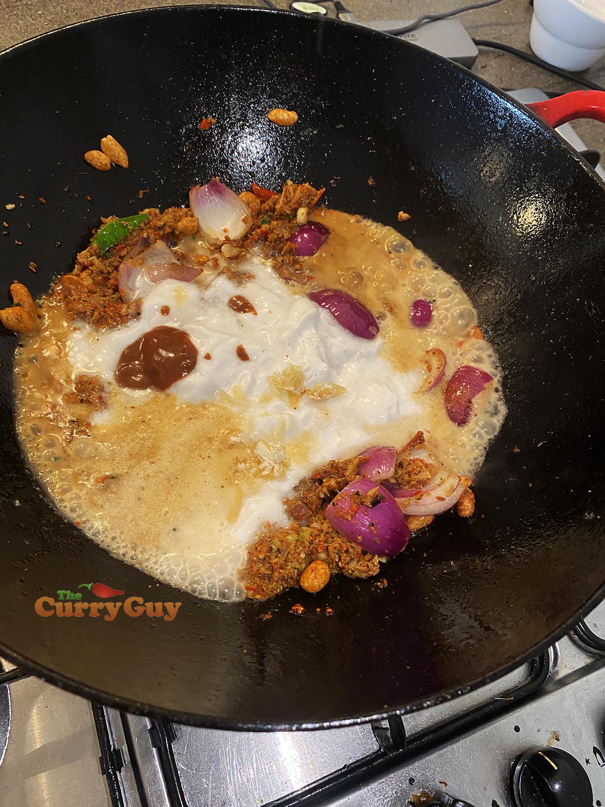 Adding coconut milk and beef to pan