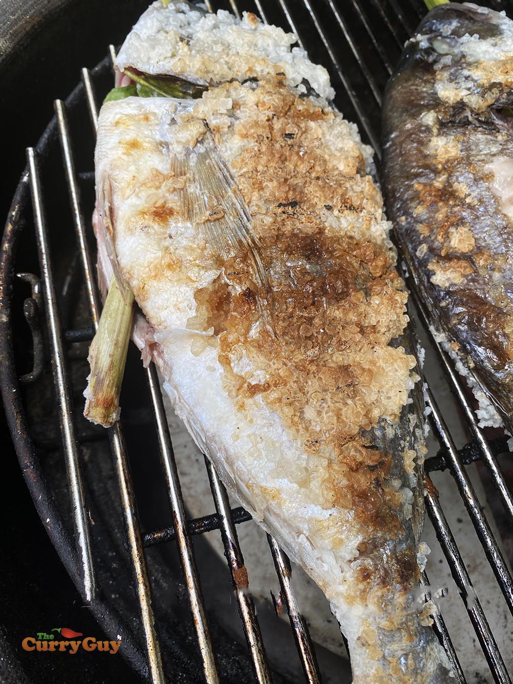 Fish cooking over a low heat on the barbecue.