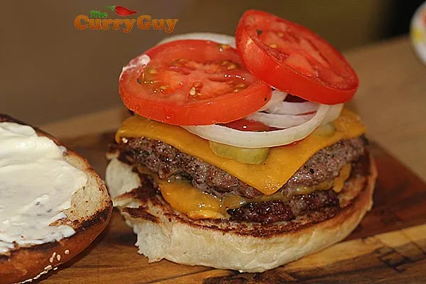 Adding tomatoes to a burger