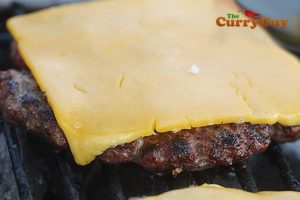 adding cheddar cheese to a burger