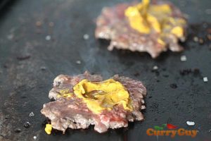 Cooking burgers with mustard