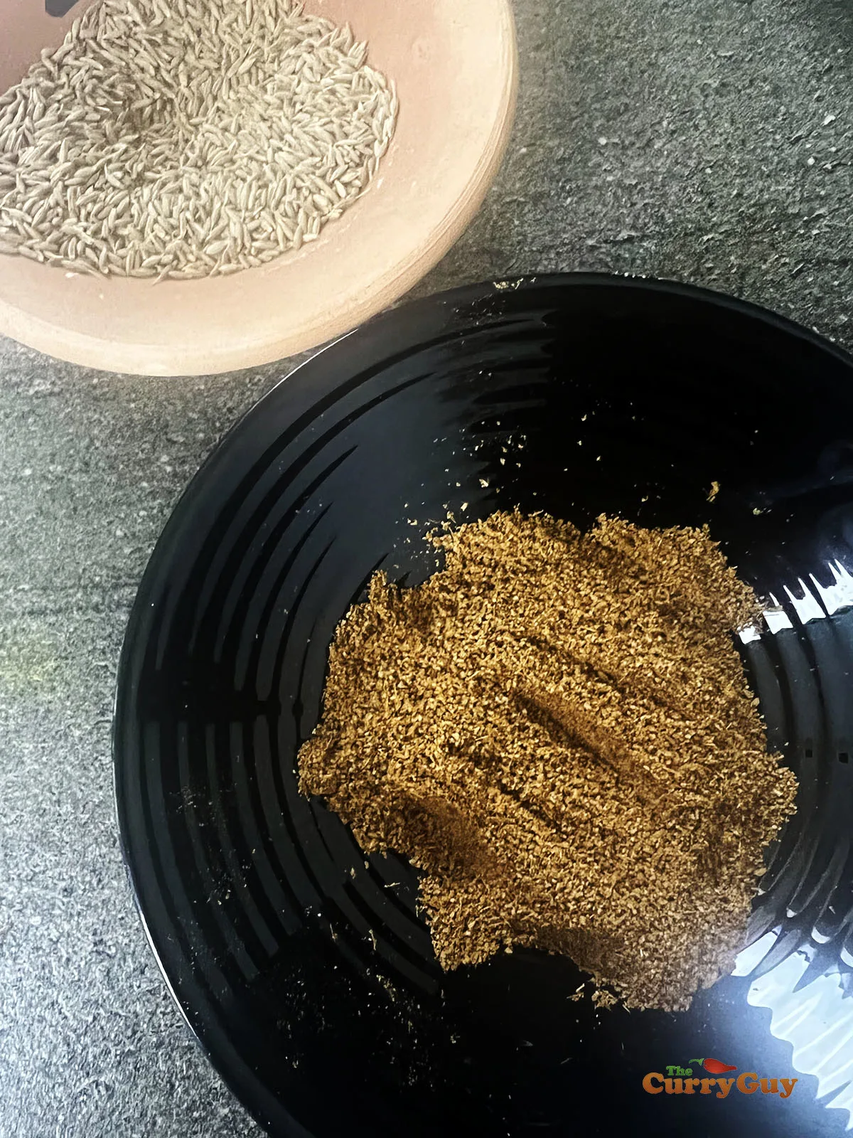 Ground cumin with whole cumin seeds also in view.
