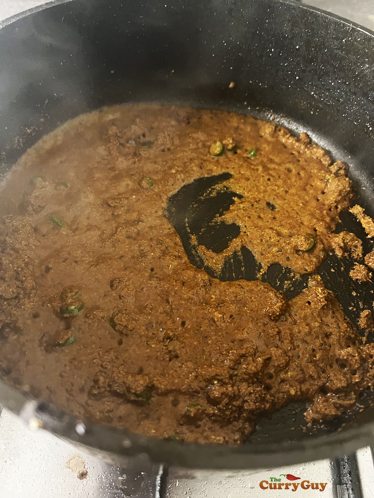 Adding ground spices and water to the pan.