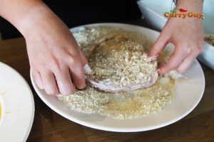putting chicken in panko bread crumbs