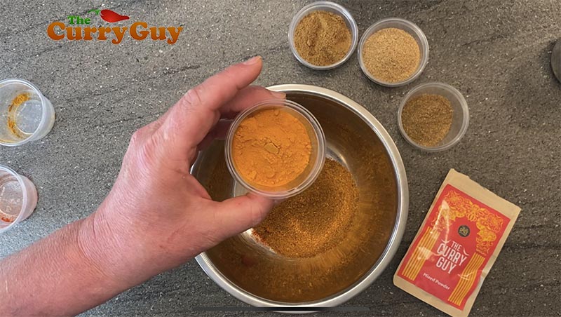 Adding turmeric to the curry powder.