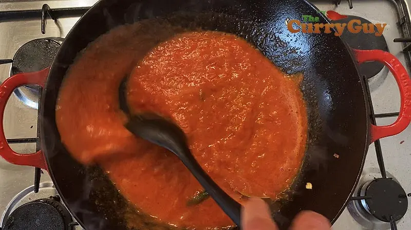 Adding tomato sauce to curry