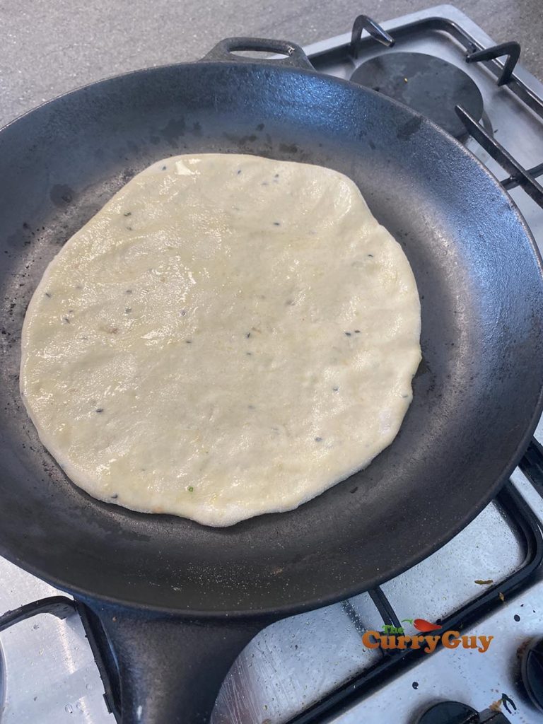 Slapping the naan into the pan