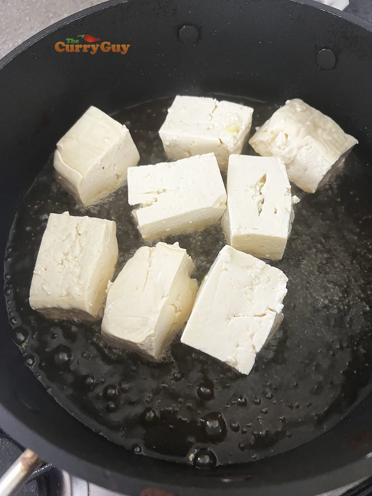 Frying the tofu, stuffing side down in the pan.