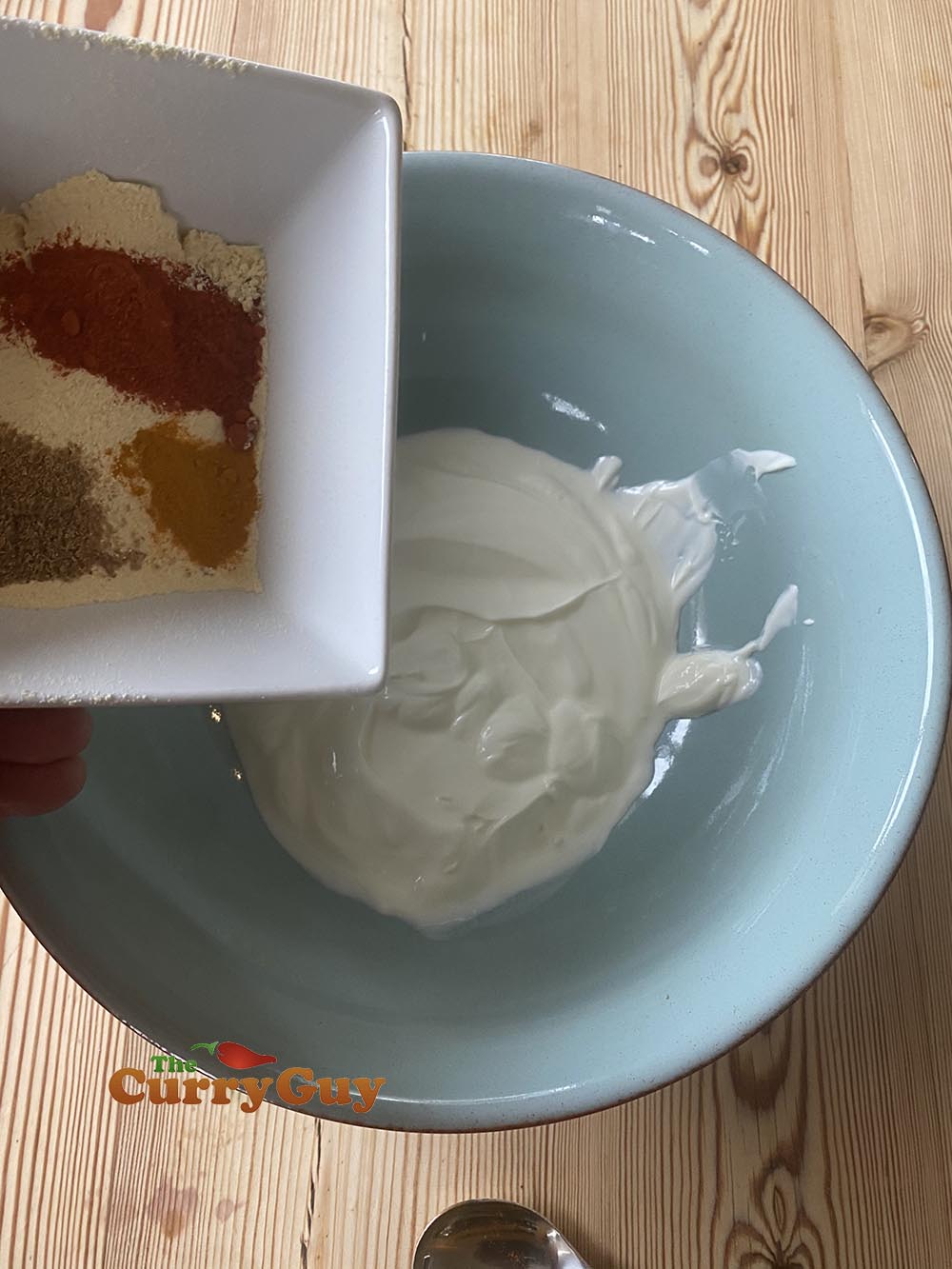adding gram flour and spices to yoghurt