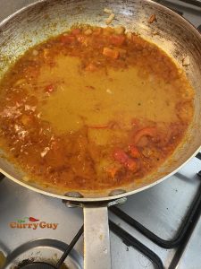 Adding base sauce and tomato puree to pan
