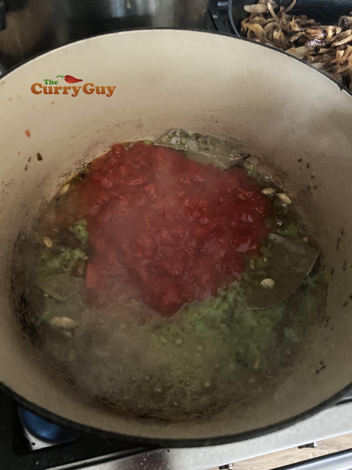 Adding chopped tomatoes to pan