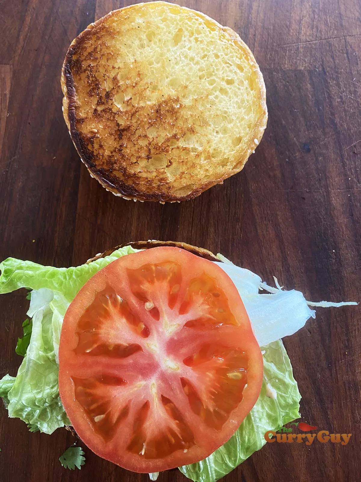 Adding tomato to burger