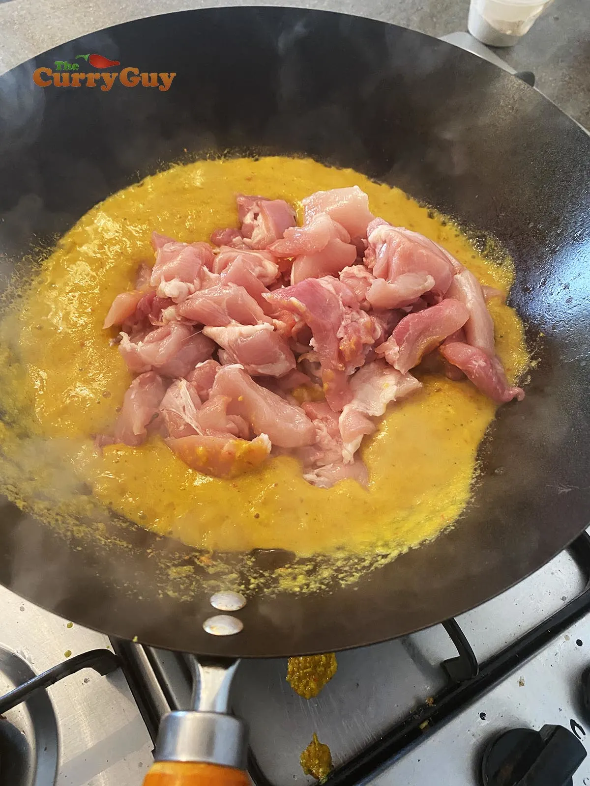 Adding chicken to sauce.