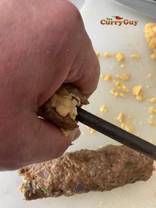 Filling seekh kebabs with cheese.