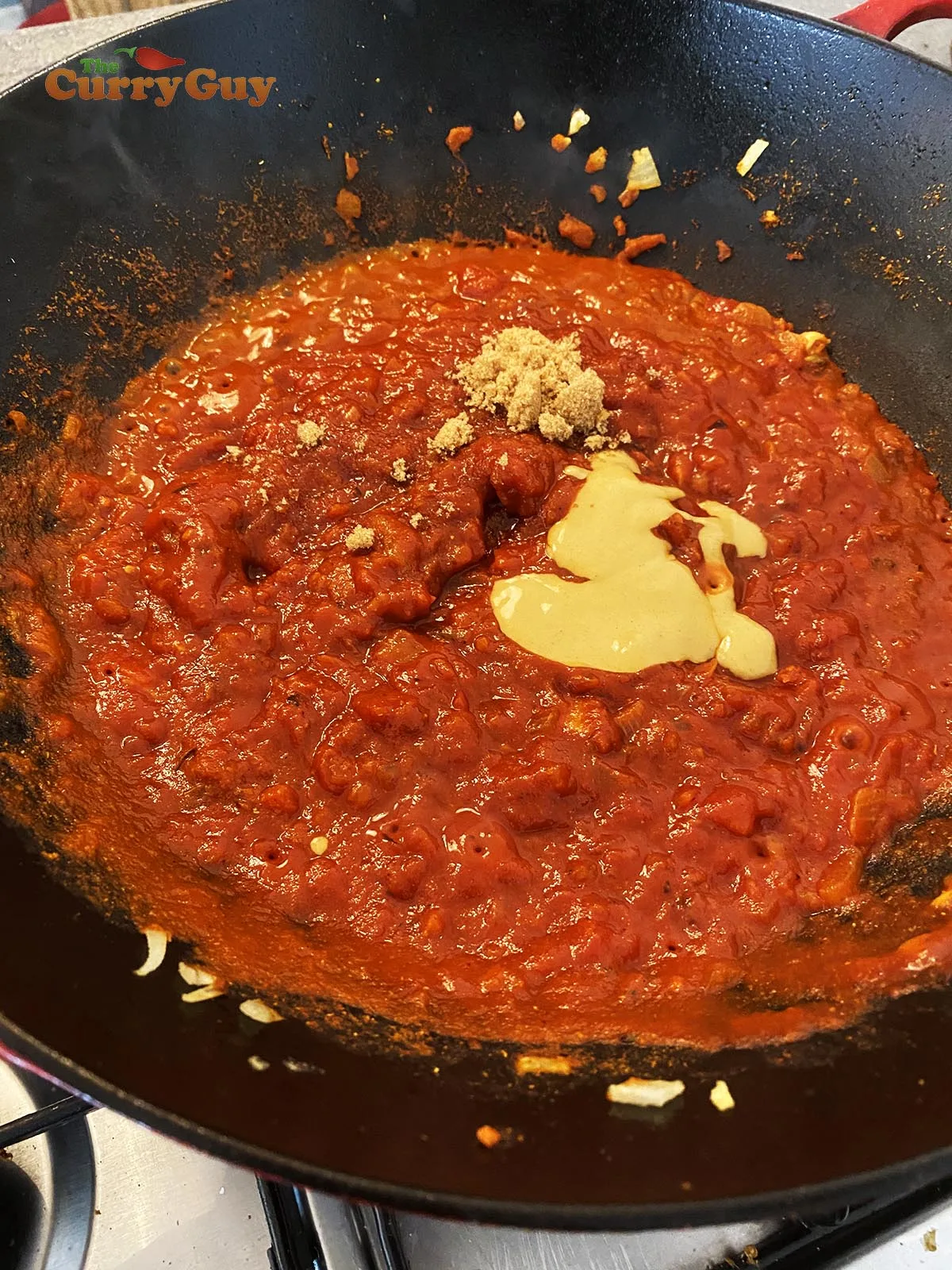 adding mustard and tomato puree to sauce