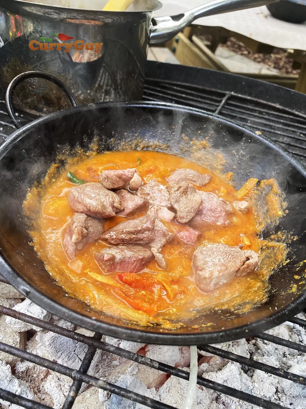 Adding base sauce and duck to balti