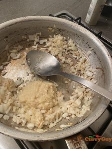 Adding garlic and ginger paste to pan