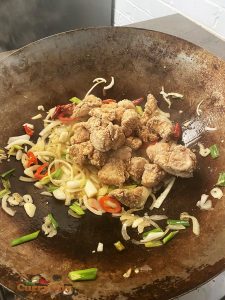 Adding chicken to wok